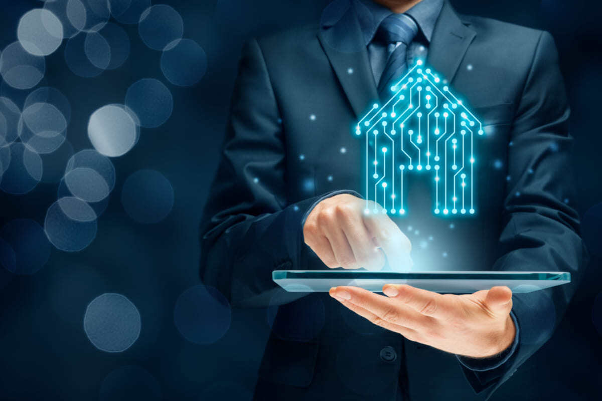 A man in a suit holding a tablet with a house made of pcb design