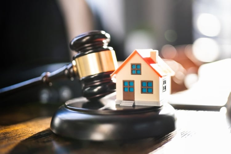 A model home on top of a gavel