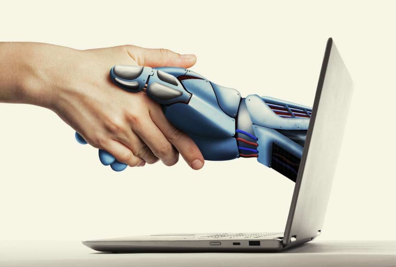 A robot hand comes out of computer screen to shake a human hand, how to use ai in digital marketing concept