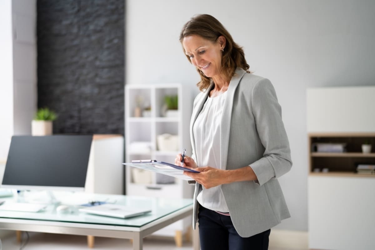 A woman in a house with a clipboard