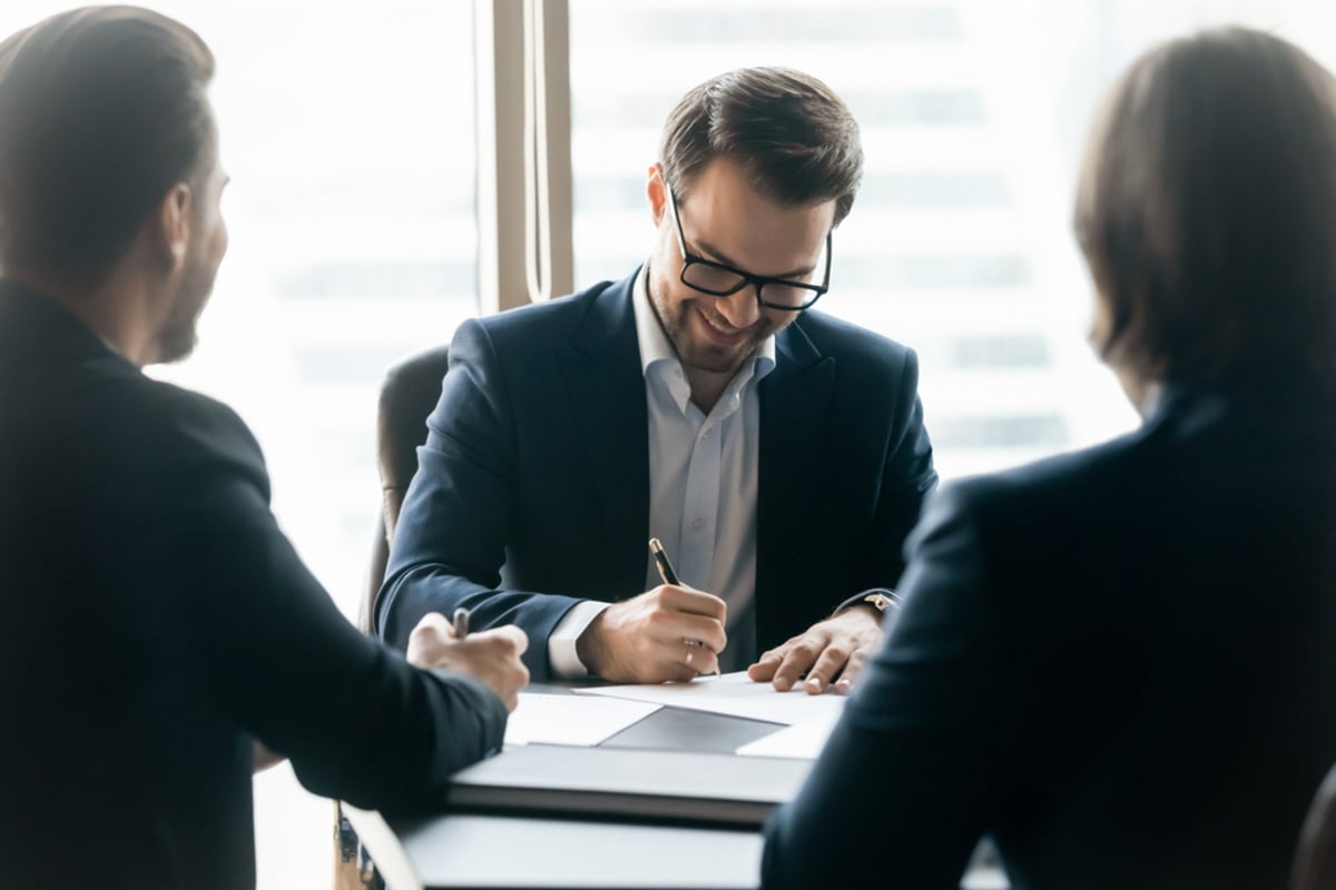 Businessman in a meeting writing on paper